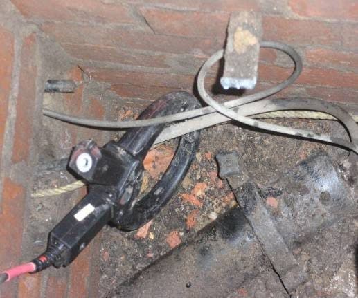 Signal clamp closed around a cable in a joint hole.
